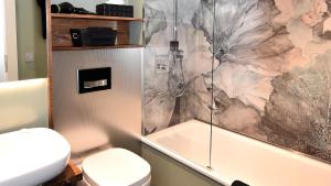 a bathroom with a toilet and a shower and a tub at Carl.22 City Appartements in Eisenach +7 photos