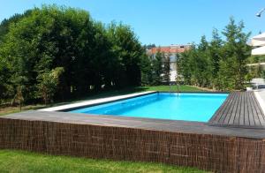 a swimming pool in a yard with a brick wall at Equinaturi in Santo Tirso