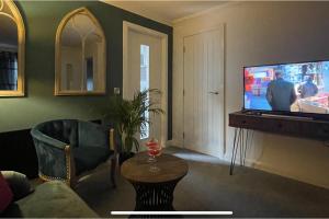 a living room with a flat screen tv and a couch at 2 Bed House - Sleeps 4 - Garden Parking Wifi in Perth