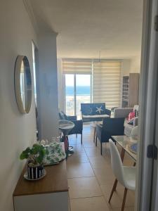 a living room with a couch and a table at Cómodo departamento in El Tabo +4 photos