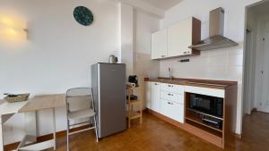 a kitchen with a stainless steel refrigerator and a table at La Casa Di Gianni in Ospedaletti