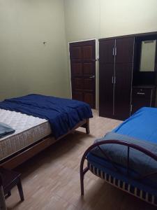 una camera da letto con due letti e un comò di Homestay Teratak Senja a Pasir Mas