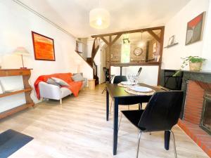 a living room with a table and a fireplace at Le clos des écureuils in Amboise