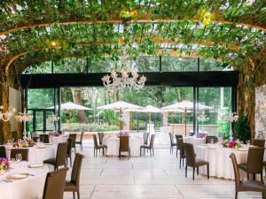 a dining room with tables and chairs and a ceiling with plants at Papadopoli Hotel Venezia - MGallery Collection in Venice