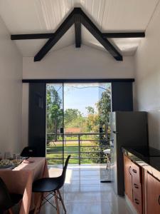 a kitchen with a table and chairs and a large window at El encuentro in Atyrá
