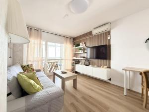 a living room with a couch and a tv at The Coastal Pearl - Beachfront 2 BR Apartment with Balcony in Fuengirola