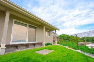 una casa con un prato verde davanti di Matsushima hill bungalow a Matsushima