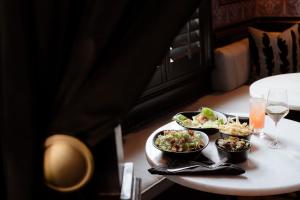a table with two plates of food and glasses of wine at Blackbird Hotel in New Orleans +72 photos