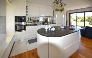 a kitchen with white cabinets and a black counter top at Maison Avec Piscine Et Jacuzzi in Allex