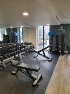 a gym with a row of treadms and weights at Cozy Broad Street Apartment Central and Comfortable in Birmingham