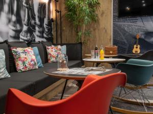 a coffee shop with a couch and tables and chairs at ibis Cannes Centre in Cannes