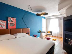 a bedroom with a bed and a blue wall at ibis Cannes Centre in Cannes +52 photos