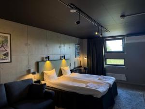 a bedroom with a large bed and a couch at Playhotel in Mjölby