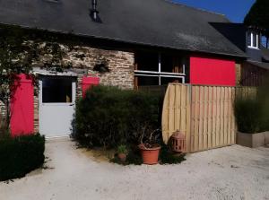 una casa de ladrillo con puertas rojas y una valla en Gîte bien-être avec spa, en Trans 13 fotos más