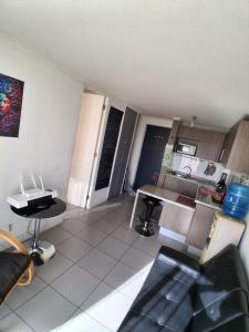 Una sala de estar con una mesa y una cocina. en Departamento Parque O'Higgins, en Santiago