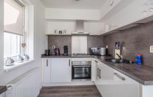 Una cocina con gabinetes blancos y un fregadero. en 3 Bedroom Nice Home In Vlagtwedde, en Vlagtwedde