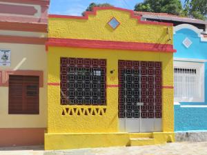 a yellow house with a gate in front of it at Chalé Carnaval Olinda 14000 RS in Olinda