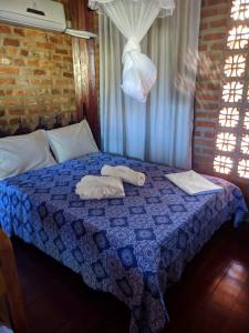 a bedroom with a bed with towels on it at Chalé Carnaval Olinda 14000 RS in Olinda