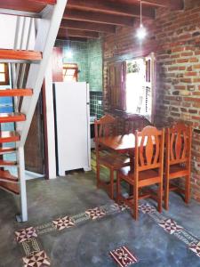 a kitchen with a table and chairs and a refrigerator at Chalé Carnaval Olinda 14000 RS in Olinda