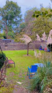 two blue chairs and a bench in a yard at Jay's crash pad in London