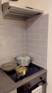 a kitchen with two pots and pans on a stove at Jay's crash pad in London +7 photos
