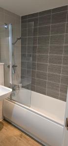 a shower with a glass door in a bathroom at Cozy Broad Street Apartment Central and Comfortable in Birmingham +30 photos