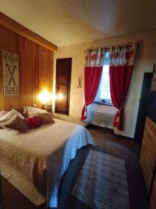 a bedroom with a bed with red curtains and a window at Appartement T3 2 chambres - 6 personnes in Luz-Saint-Sauveur