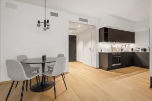eine Küche und ein Esszimmer mit Tisch und Stühlen in der Unterkunft Moderne leilighet i Vannkunsten Syd in Oslo + 14 Fotos