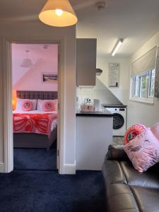 a room with a bed and a couch and a kitchen at The Raven Pub with Rooms in Claines