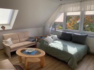a living room with a couch and a bed and a table at 2-Zimmer Ferienwohnung am Teutoburger Wald in Lage
