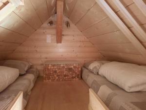 ジェドルにあるChalet cosy avec vue magiqueの丸太造りの小さな家に2つのベッド +3枚の写真