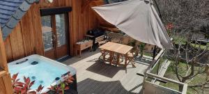 ジェドルにあるChalet cosy avec vue magiqueのパティオ(ホットタブ、パラソル付)