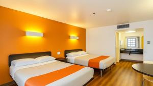 a hotel room with two beds and a table at Motel 6-Carlsbad, CA Beach in Carlsbad