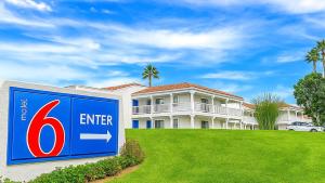 a house with a sign in front of it at Motel 6-Carlsbad, CA Beach in Carlsbad