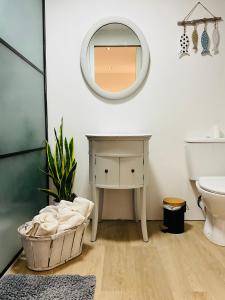 baño con tocador y espejo en la pared en Hôte Labyrinthe sur la place chambres d, hôtes , calme ,Netflix, en Mirepoix