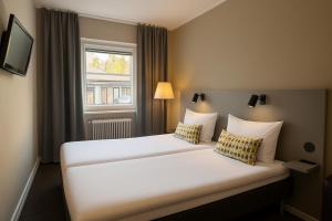 a hotel room with a large white bed with two pillows at Hotell Drott in Norrköping +12 photos