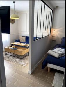 a living room with a couch and a table at Charmant Studio Balneo wifi clim borne electrique in Vierzon