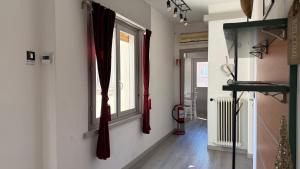 a hallway with red curtains and a window at Centro Città 2 in Gorizia