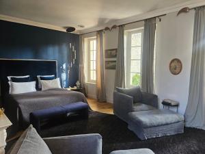 a bedroom with a bed and a chair at La Divine Comédie-Suites Deluxe in Avignon +68 photos