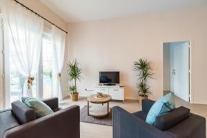 a living room with two couches and a tv at Résidence de Perros-Guirec in Perros-Guirec