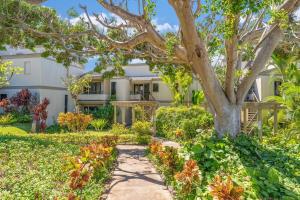 a house with a tree in the yard at Wailea Ekolu 1604 · WE 1604 Wailea 2BD Condo w AC Pool Near Beac in Kihei