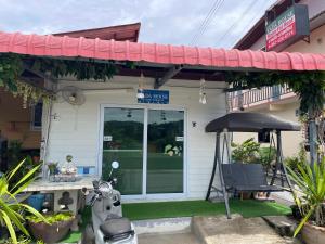 a motorcycle parked in front of a house with an umbrella at Yada House s&s in Nai Yang Beach +19 photos