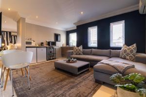 un salon avec un canapé et une table dans l'établissement Thesen Harbour Town Apartments @ Beautiful Knysna Villas, à Knysna