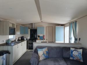 een woonkamer met een bank en een keuken bij H26 at Silversands in Lossiemouth