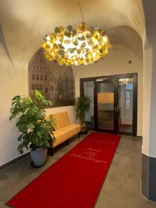 a living room with a couch and a red rug at Hotel Schwibbogen Altstadt & Apartments in Görlitz