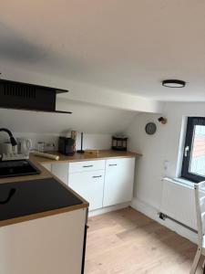 a kitchen with white cabinets and a black counter top at Fewo Donna in Altensteig