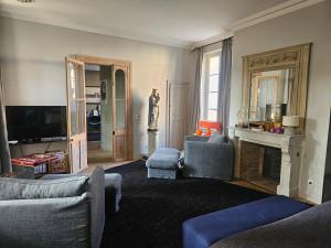 a living room with two chairs and a fireplace at La Divine Comédie-Suites Deluxe in Avignon