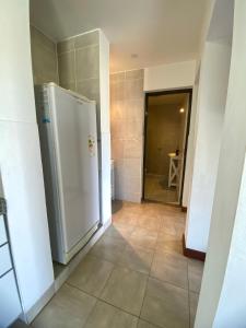 a kitchen with a white refrigerator in a hallway at Complejo Abuela Lety in Merlo