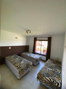 three beds sitting in a room with a window at Complejo Abuela Lety in Merlo +24 photos