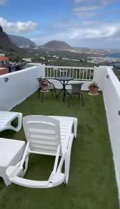 a patio with a table and chairs on a roof at Gar House in Caleta de Interián